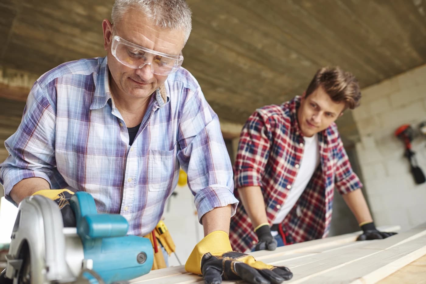 Transmission d’un savoir-faire entre deux générations dans un atelier.